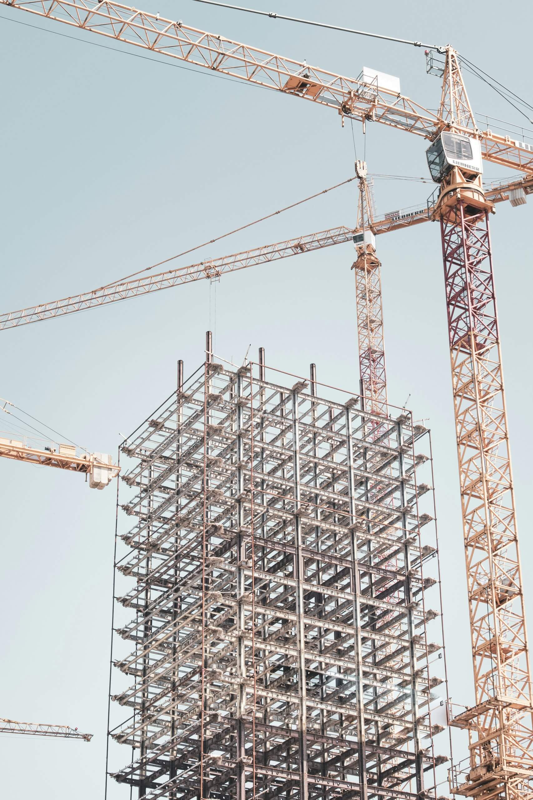 Construction d'un bâtiment en charpente métallique avec plusieurs grues