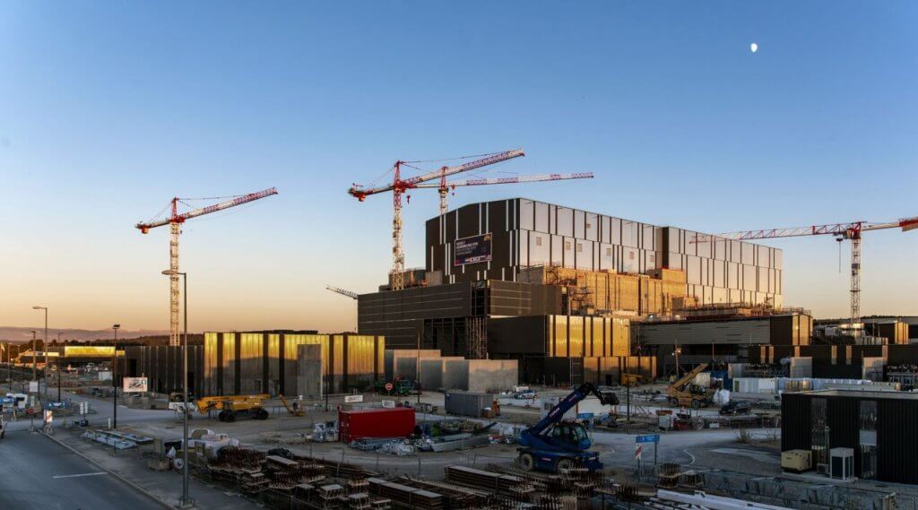 Vue en perspective d'un bâtiment en construction avec 3 grues
